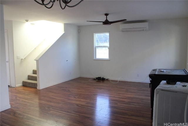 living room featuring an AC wall unit, dark hardwood / wood-style flooring, and ceiling fan with notable chandelier