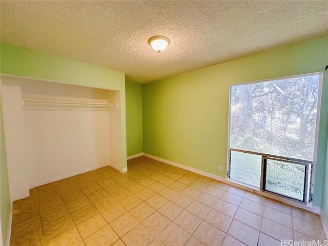 tiled empty room with a textured ceiling