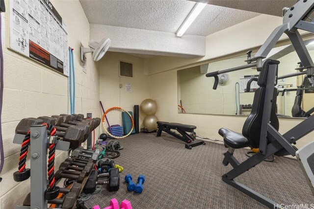 workout room with a textured ceiling