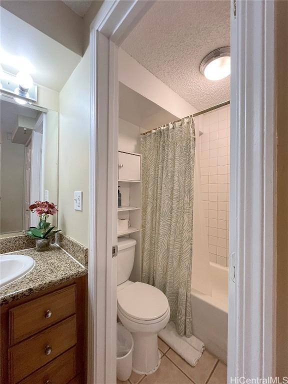 full bathroom featuring toilet, tile patterned flooring, shower / tub combo, a textured ceiling, and vanity