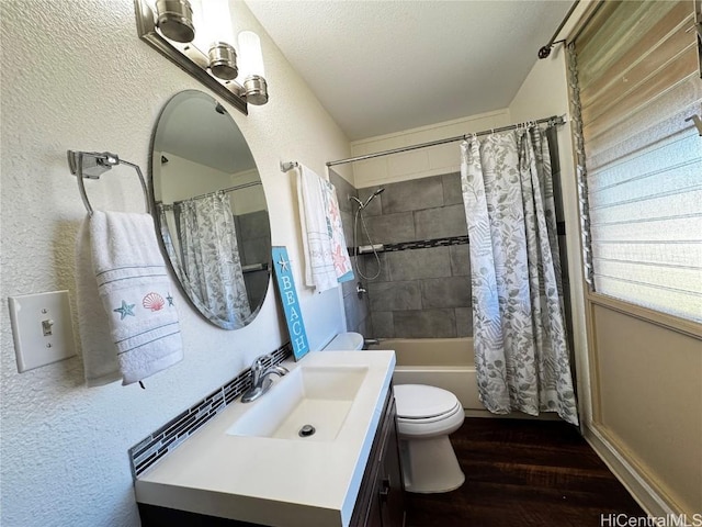 full bathroom featuring a textured ceiling, vanity, toilet, hardwood / wood-style flooring, and shower / bath combo