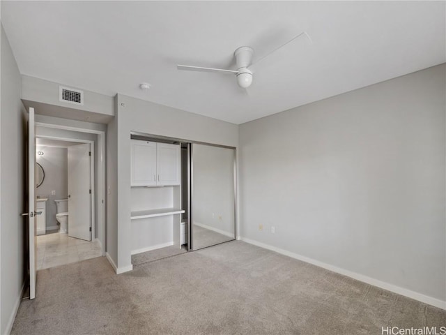 unfurnished bedroom with light carpet, a closet, and ceiling fan