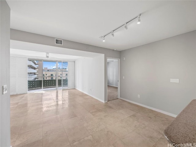 empty room featuring ceiling fan and rail lighting