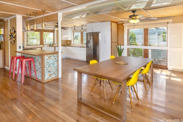 dining area with ceiling fan and light hardwood / wood-style flooring