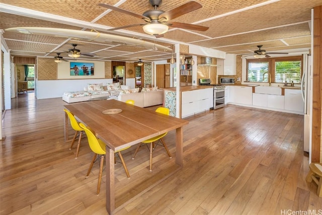 dining area with sink and light wood-type flooring