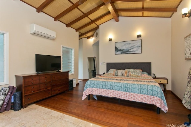 bedroom with beam ceiling, a wall mounted AC, light hardwood / wood-style flooring, and wooden ceiling