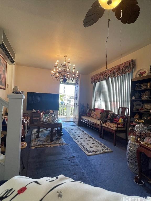 carpeted living room featuring ceiling fan with notable chandelier and an AC wall unit