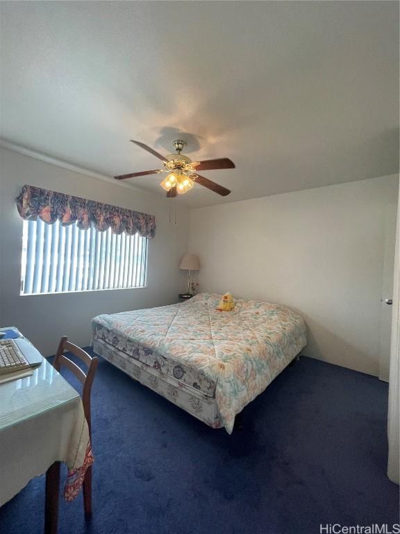 bedroom with ceiling fan and dark carpet