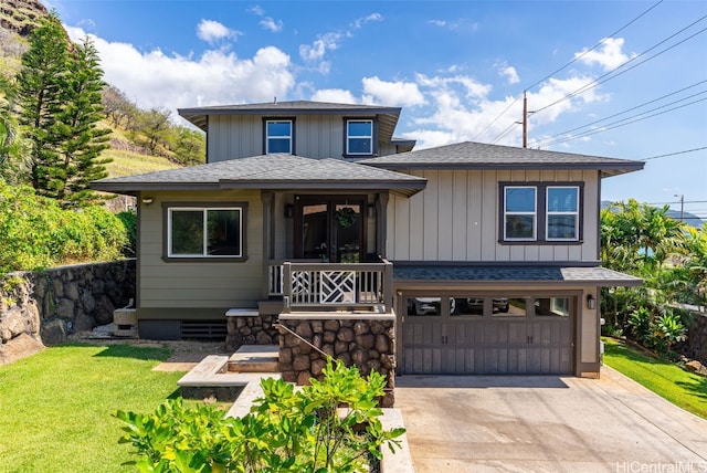 view of front of home featuring a porch, a garage, and a front lawn