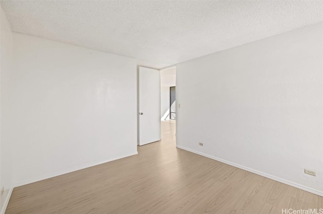 unfurnished room featuring a textured ceiling and light hardwood / wood-style flooring