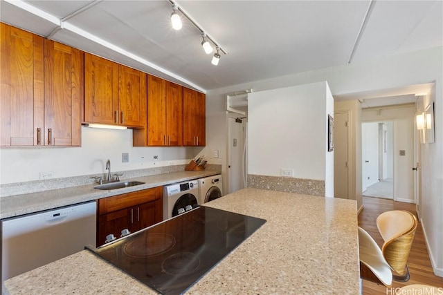 kitchen with black electric stovetop, dishwasher, light stone counters, and sink