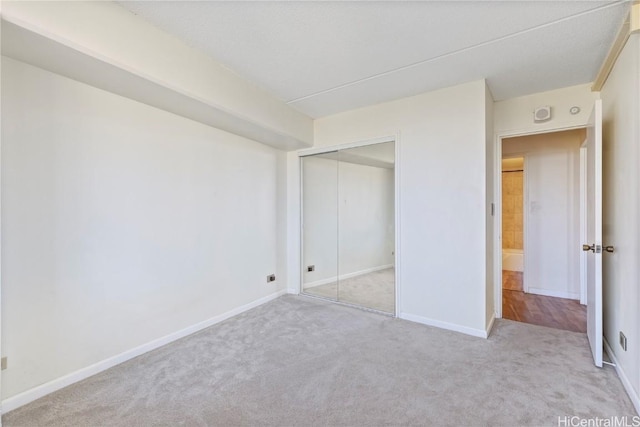 unfurnished bedroom with a closet and light carpet