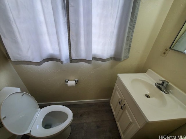 bathroom with vanity, toilet, and wood-type flooring