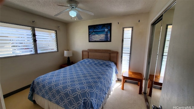 bedroom with light colored carpet, ceiling fan, and a textured ceiling