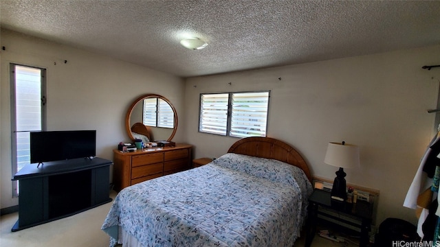 bedroom with light colored carpet and a textured ceiling