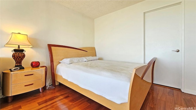 bedroom featuring dark hardwood / wood-style floors and a textured ceiling