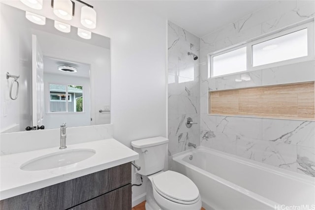 full bathroom with vanity, tiled shower / bath combo, and toilet