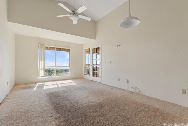 carpeted spare room with ceiling fan and high vaulted ceiling