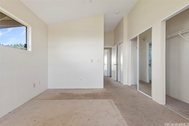 unfurnished bedroom featuring multiple closets and light colored carpet