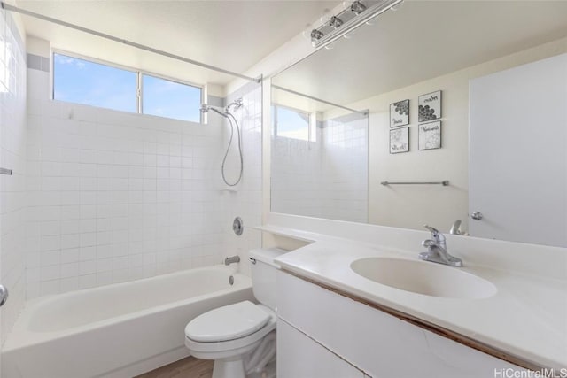 full bathroom featuring vanity, tiled shower / bath combo, wood-type flooring, and toilet