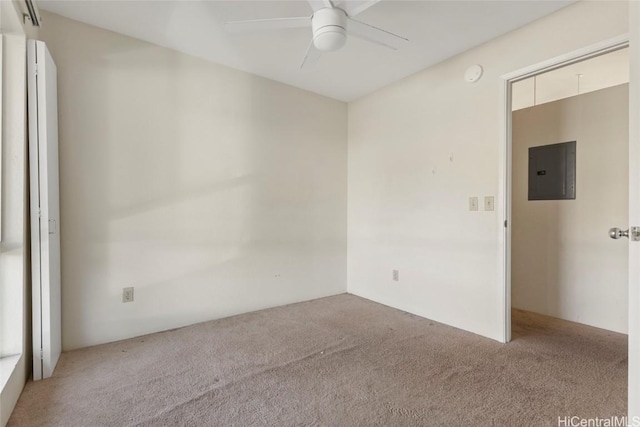 spare room featuring light colored carpet, electric panel, and ceiling fan