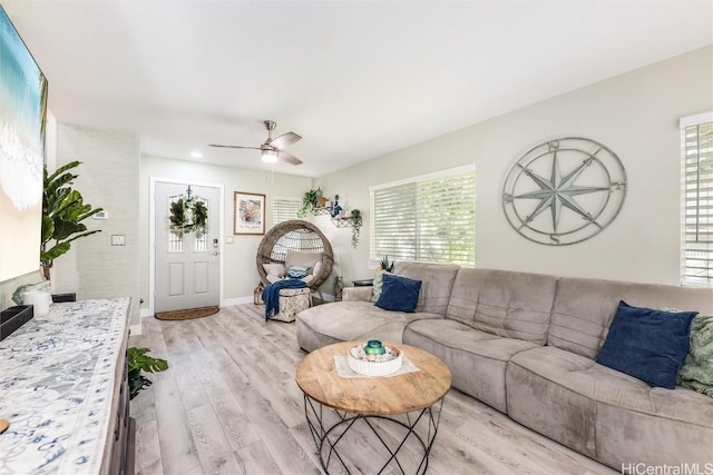 living room with ceiling fan and light wood-type flooring