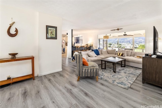 living room featuring light hardwood / wood-style floors and ceiling fan