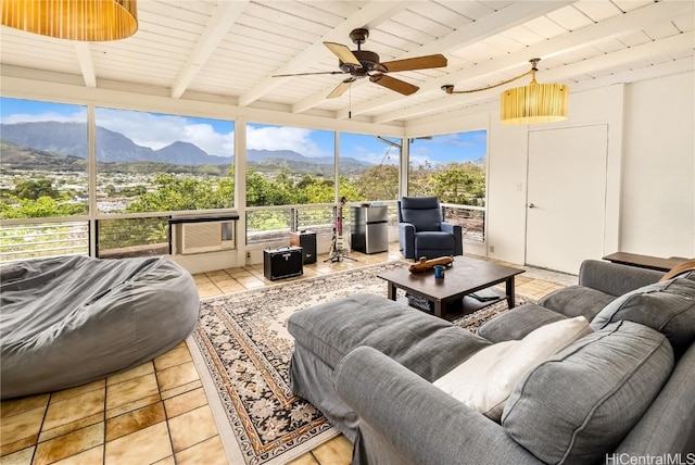 sunroom featuring a mountain view, beam ceiling, and ceiling fan