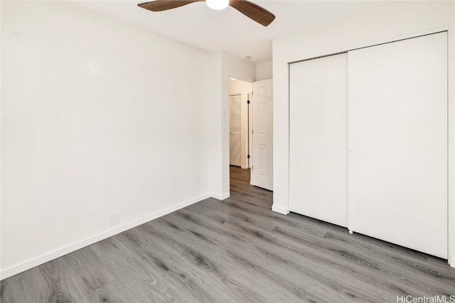 unfurnished bedroom featuring wood-type flooring, a closet, and ceiling fan