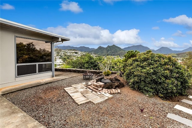 view of yard featuring an outdoor fire pit and a mountain view