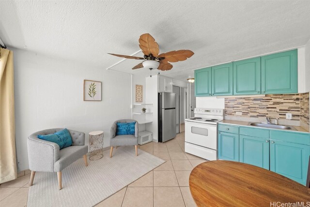 kitchen featuring stainless steel fridge, white range with electric stovetop, ceiling fan, light tile patterned flooring, and sink