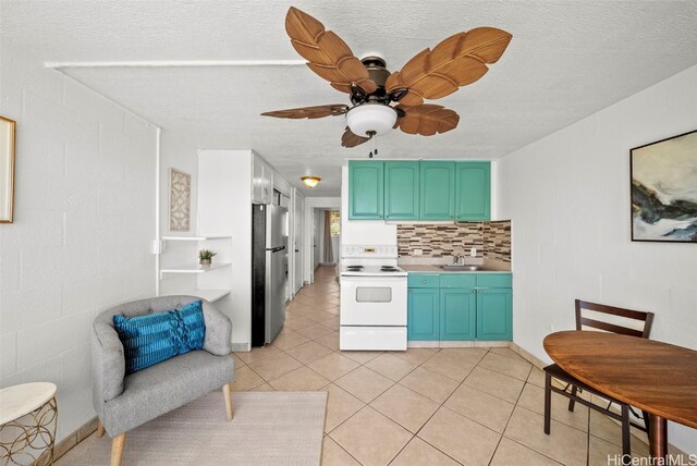 kitchen with white range with electric cooktop, sink, backsplash, stainless steel fridge, and light tile patterned floors