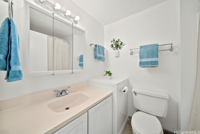 bathroom featuring a textured ceiling, toilet, tile patterned flooring, and vanity