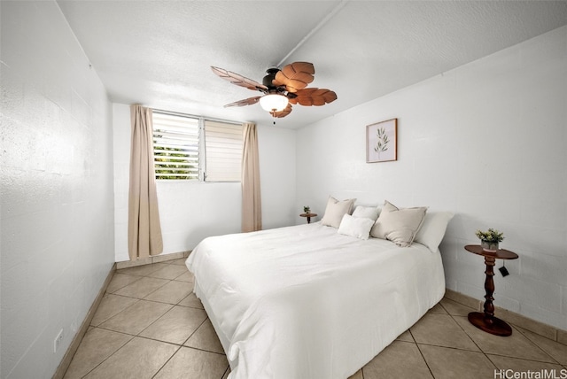 bedroom featuring ceiling fan, light tile patterned flooring, and a textured ceiling