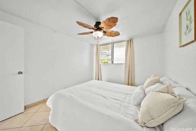 bedroom with ceiling fan, a textured ceiling, and light tile patterned floors