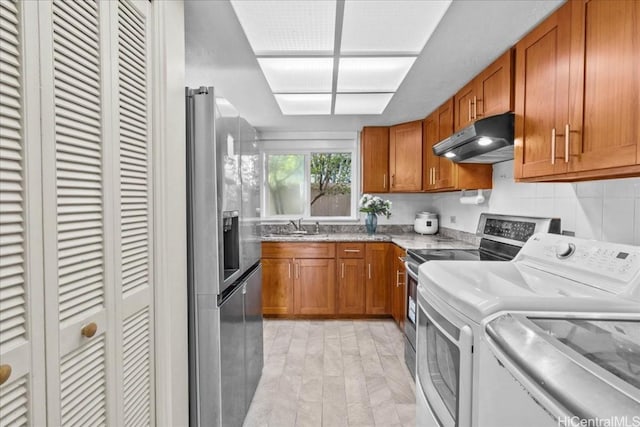 kitchen with stainless steel appliances, sink, backsplash, and washer and clothes dryer