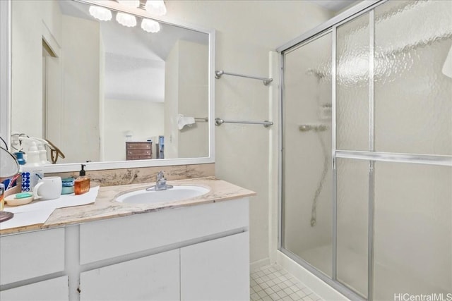 bathroom featuring vanity, a shower with shower door, and tile patterned flooring