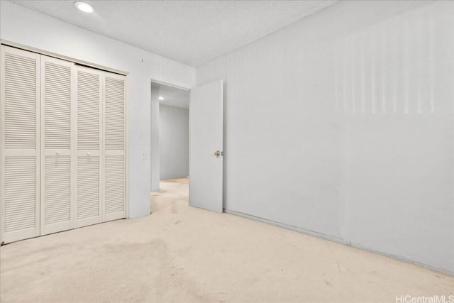 unfurnished bedroom featuring light colored carpet and a closet