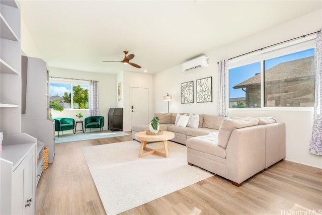 living room with ceiling fan, light wood-type flooring, and a wall unit AC