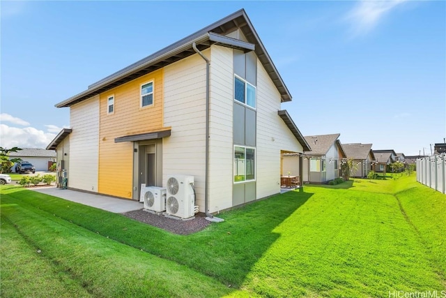 rear view of house featuring ac unit, a patio area, and a yard