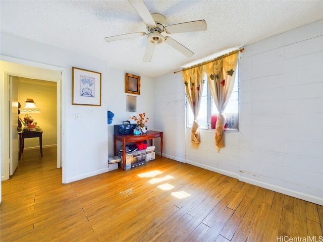 unfurnished room featuring a textured ceiling, ceiling fan, and light wood-type flooring