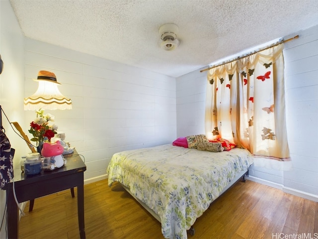 bedroom with a textured ceiling and hardwood / wood-style flooring