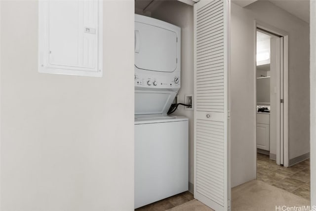 washroom featuring light colored carpet, electric panel, and stacked washer and dryer