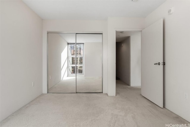 unfurnished bedroom featuring a closet and light carpet