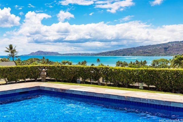 view of swimming pool featuring a water and mountain view