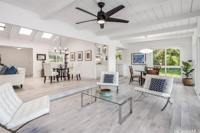 living room with wood ceiling, lofted ceiling with skylight, light hardwood / wood-style floors, and ceiling fan with notable chandelier