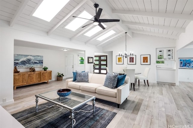 living room featuring beam ceiling, ceiling fan with notable chandelier, light wood-type flooring, and a skylight