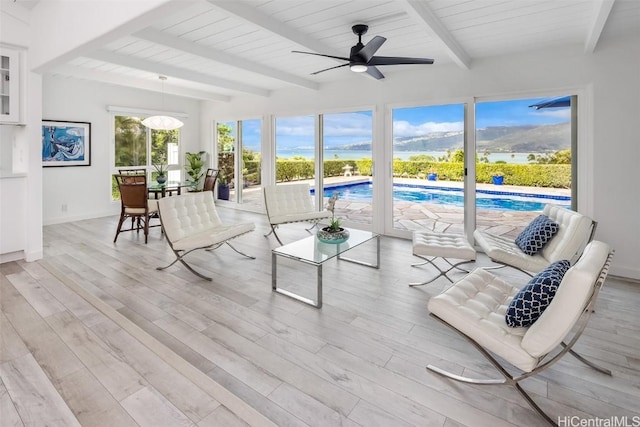 sunroom with ceiling fan, wooden ceiling, and beam ceiling