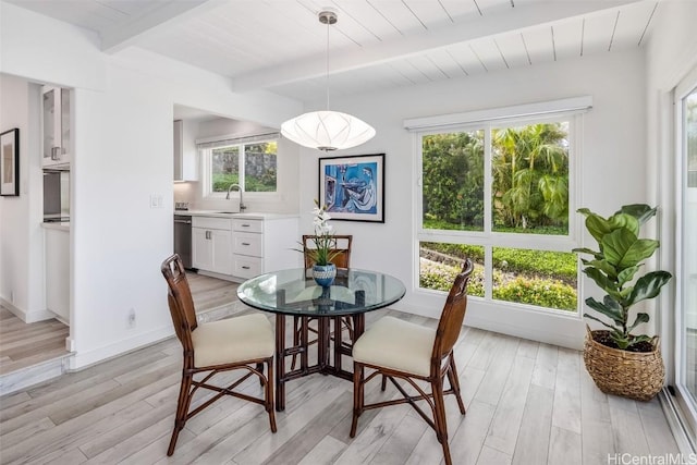 dining area featuring beamed ceiling, wood ceiling, sink, and light wood-type flooring