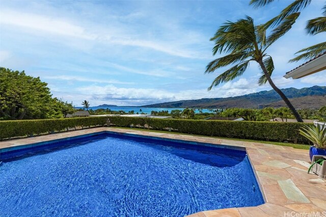 view of swimming pool with a patio and a water and mountain view